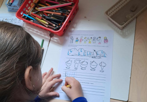 Dziewczyna rozwiązuje karty pracy z literką l.