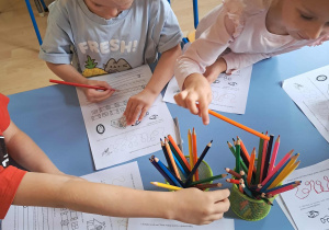 Dzieci wykonują karty pracy z literą O.