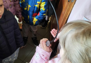Weterynarz pokazuje dzieciom stetoskop.