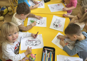 Dzieci siedzą przy stoliku.