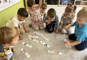 Dzieci siedzą na dywanie.