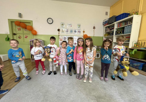 Dzieci stoją na dywanie.