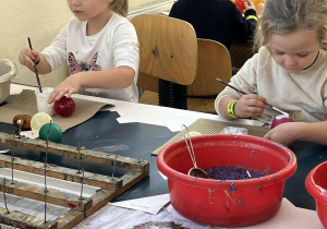 Dziewczynki malują bombki.