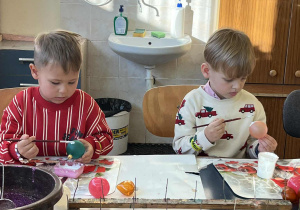 Chłopcy malują bombki.