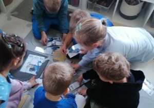 Dzieci układają smerfowe puzzle.