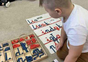 Chłopiec układa wyraz z liter i dopasowuje do odpowiedniego obrazka.