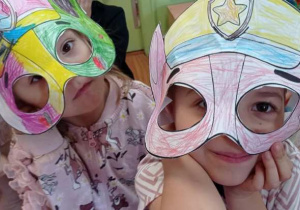 Dzieci pokazują wykonane przez siebie maski postaci z Psiego Patrolu.