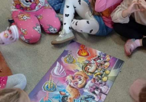 Dzieci pokazują ułożone puzzle.