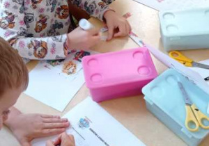 Dzieci poprawiają alfabet po śladzie.