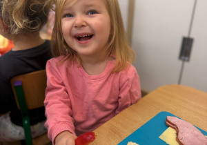 Dziewczynka smaruje masłem kromke chleba.