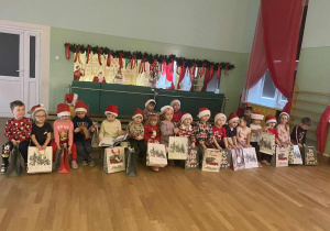 Dzieci trzymają prezenty.