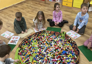 Dzieci siedzą w kole.