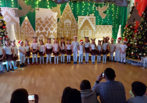 Dzieci występują przed publicznością śpiewając piosenkę.