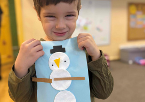 Chłopiec trzyma prace plastyczną