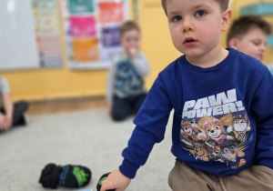 Dziecko klęczy na dywanie podczas zabawy matematycznej .