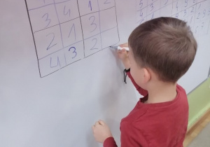 Chłopiec wpisuje cyfrę w „Sudoku” 4x4
