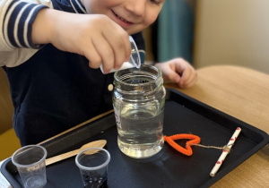 Leon wsypuje sól do słoika.