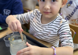 Valeriia miesza łyżeczką roztwór.