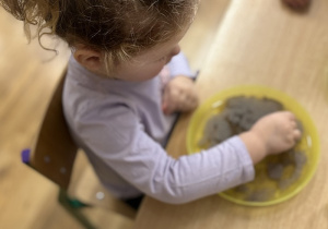 Lenka wkłada patyczek na talerz.