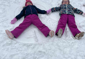 Dziewczynki robią aniołki na śniegu