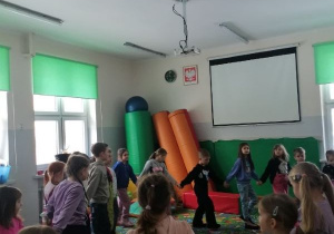 Dzieci tańczą w kole.