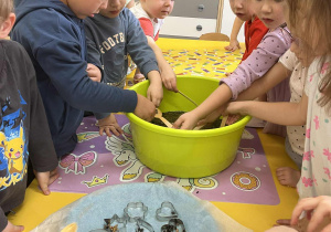 Przedszkolaki stoją obok miski