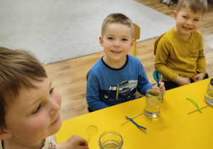 Dzieci siedzą przy stolikach.