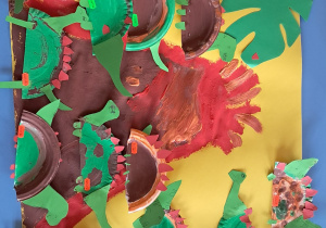 Kolorowa praca plastyczna z dinozaurami wykonana przez dzieci.