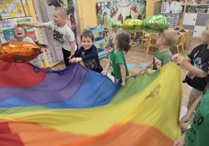 Dzieci bawią się wspólnie z chustą animacyjną.