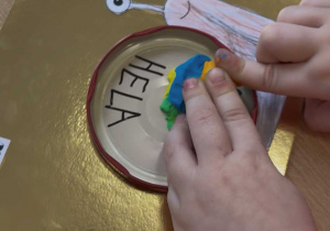 Dziewczynka wylepia z plasteliny.