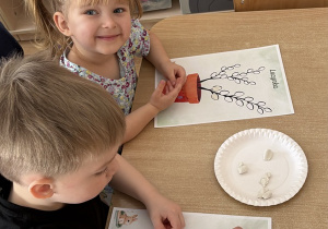 Dzieci wylepiają plasteliną bazie kotki.