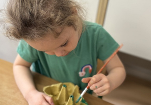 Iga maluje wytłaczankę.