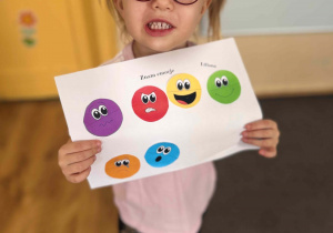 Dziewczynka trzyma swoją prace z emocjami.