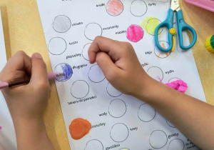 Zdjęcie przedstawiające dzieci podczas wykonywania pracy plastycznej z okazji dnia kropk.